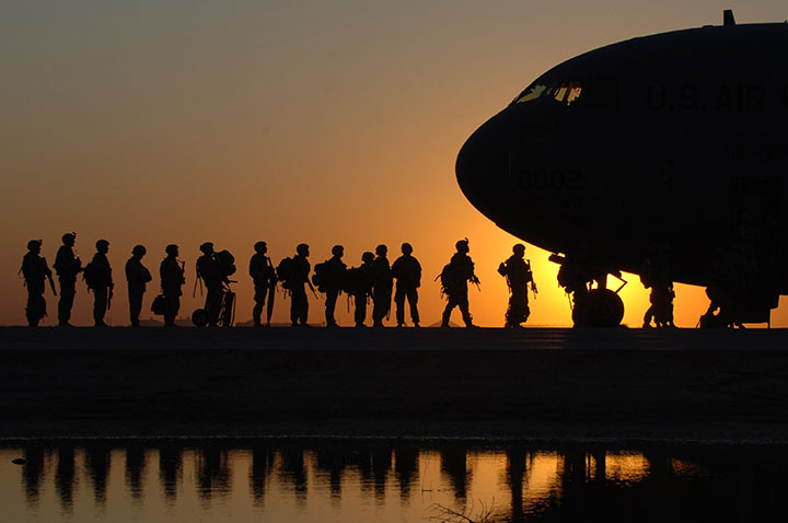 silhouette of military personnel boarding aircraft